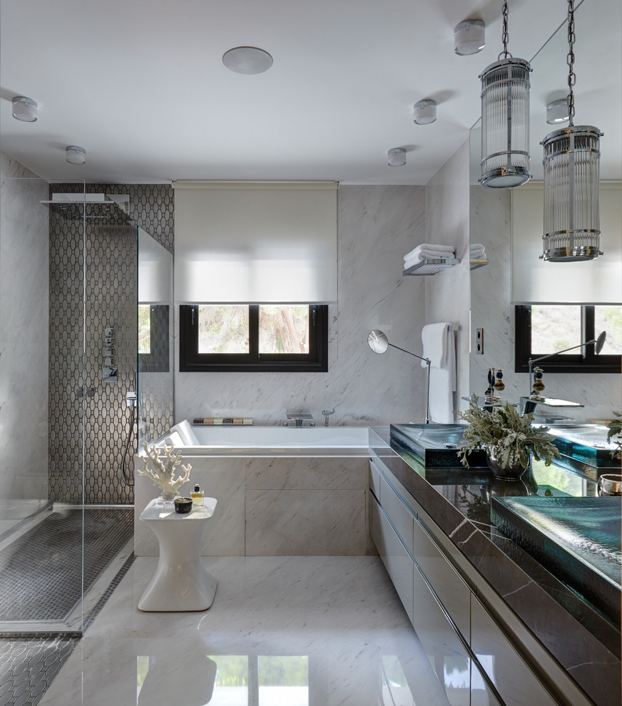 Imagen de cuarto de baño principal actual con armarios con paneles lisos, puertas de armario grises, bañera empotrada, suelo blanco y encimeras grises