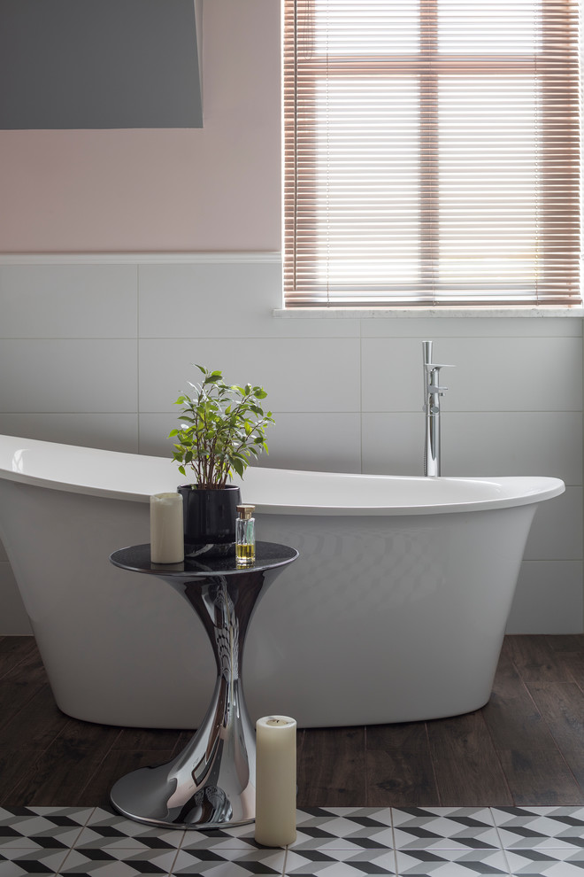 Modelo de cuarto de baño principal contemporáneo con bañera exenta y paredes rosas