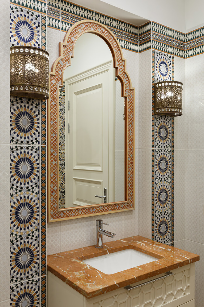 Идея дизайна: ванная комната в восточном стиле с белыми фасадами, разноцветной плиткой, врезной раковиной и коричневой столешницей