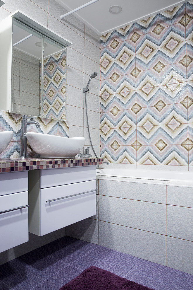Источник вдохновения для домашнего уюта: большая детская ванная комната в стиле фьюжн с плоскими фасадами, полновстраиваемой ванной, душем в нише, инсталляцией, розовой плиткой, плиткой мозаикой, белыми стенами, полом из мозаичной плитки, накладной раковиной, стеклянной столешницей, фиолетовым полом, шторкой для ванной и фиолетовой столешницей