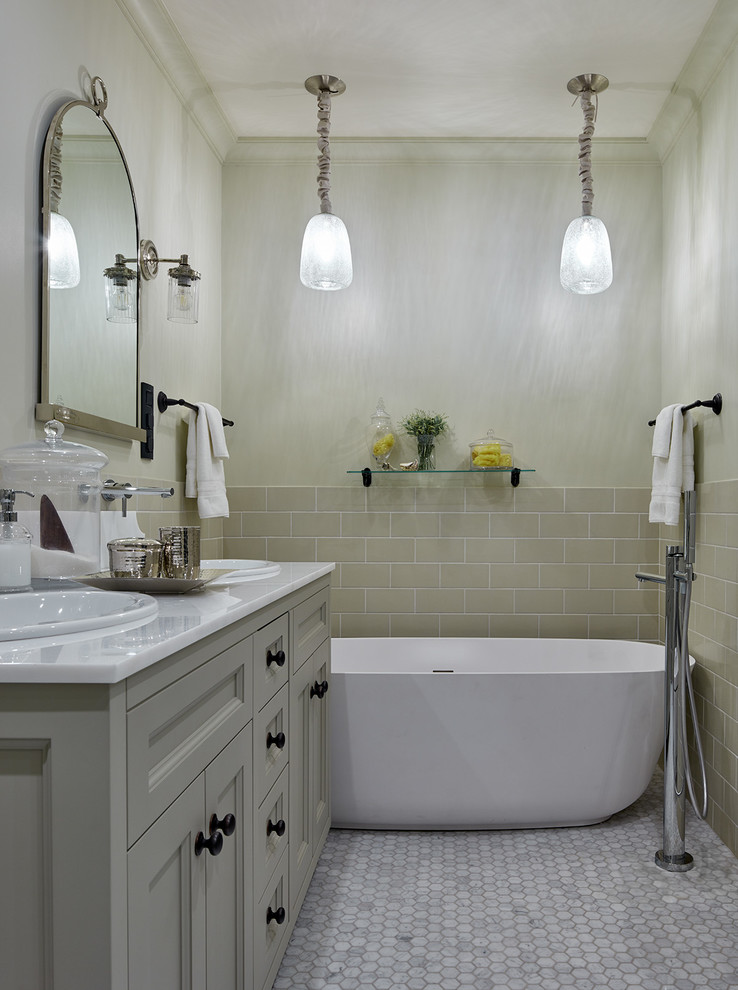 Modern inredning av ett mellanstort en-suite badrum, med luckor med infälld panel, ett fristående badkar, ett nedsänkt handfat, grå skåp, marmorgolv, marmorbänkskiva, beige kakel och beige väggar