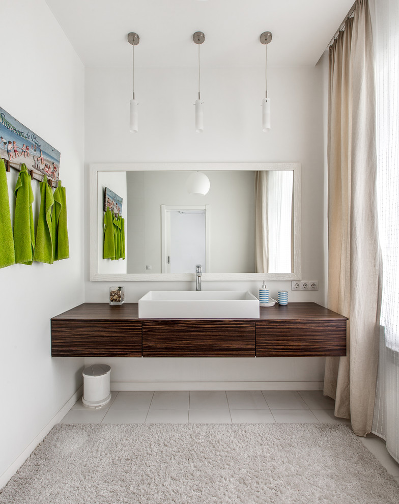 Idéer för funkis badrum, med vita väggar, klinkergolv i porslin, ett fristående handfat, släta luckor, skåp i mörkt trä och träbänkskiva