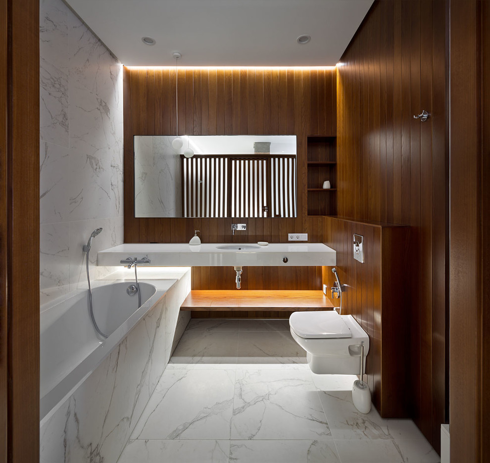 Ejemplo de cuarto de baño contemporáneo con armarios abiertos, bañera encastrada, sanitario de pared y lavabo bajoencimera