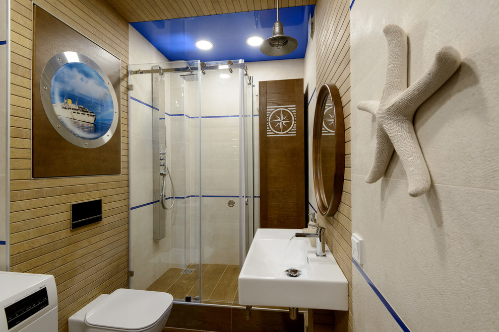 Imagen de cuarto de baño costero con ducha esquinera, sanitario de dos piezas, paredes marrones, aseo y ducha, lavabo suspendido y ducha con puerta corredera