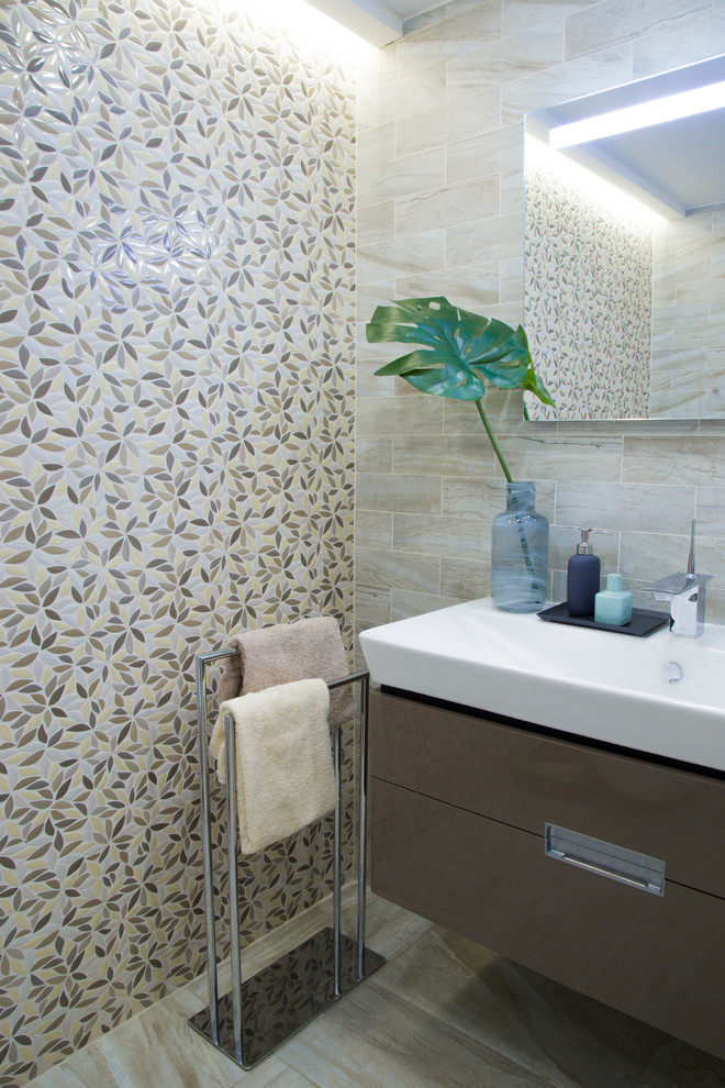 Cette image montre une salle de bain design de taille moyenne avec un placard à porte plane, des portes de placard grises et un lavabo intégré.