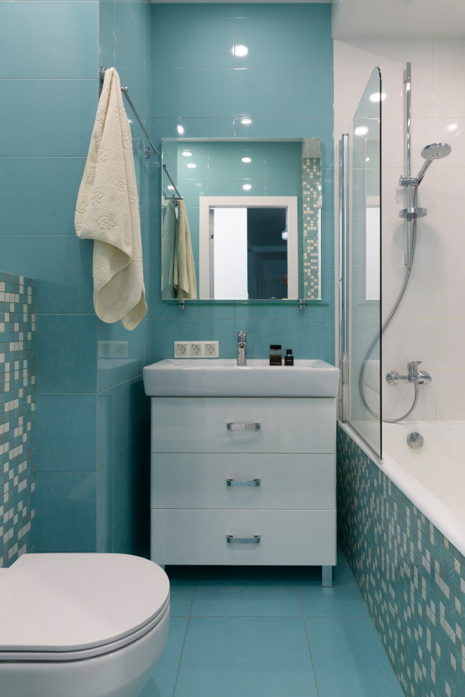Foto di una stanza da bagno con doccia minimal con ante bianche, vasca ad alcova, WC sospeso, piastrelle blu, piastrelle in ceramica, pavimento con piastrelle in ceramica, pavimento blu, doccia con tenda, top bianco e un lavabo