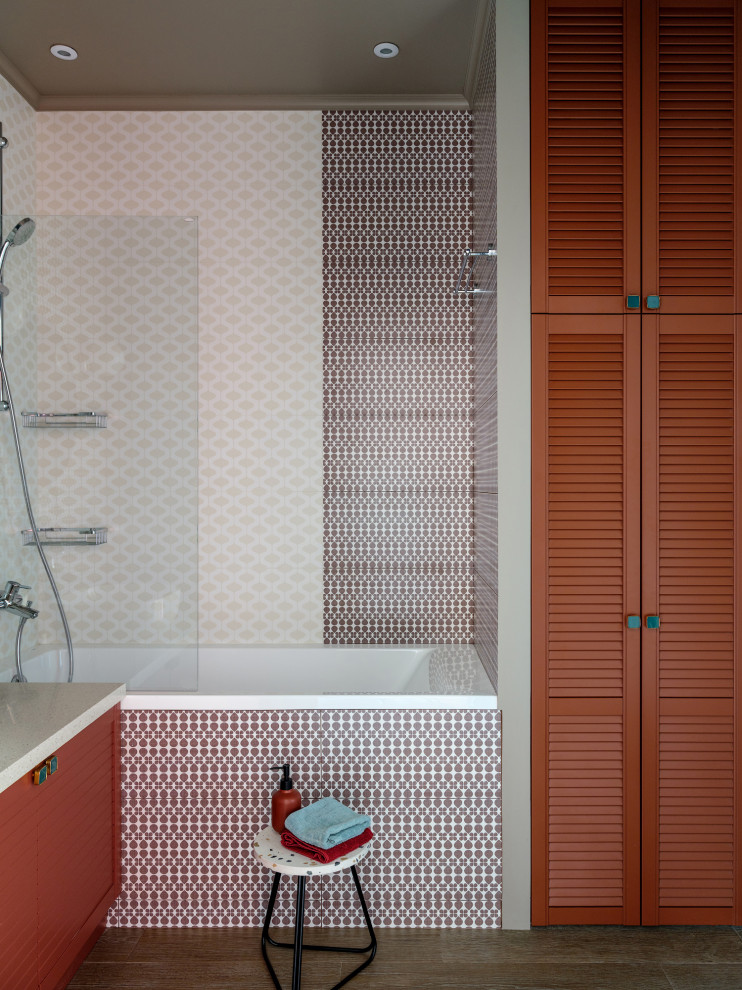 Exempel på ett litet modernt beige beige en-suite badrum, med luckor med lamellpanel, bruna skåp, ett undermonterat badkar, en vägghängd toalettstol, flerfärgad kakel, keramikplattor, flerfärgade väggar, klinkergolv i keramik, ett nedsänkt handfat, bänkskiva i akrylsten och brunt golv