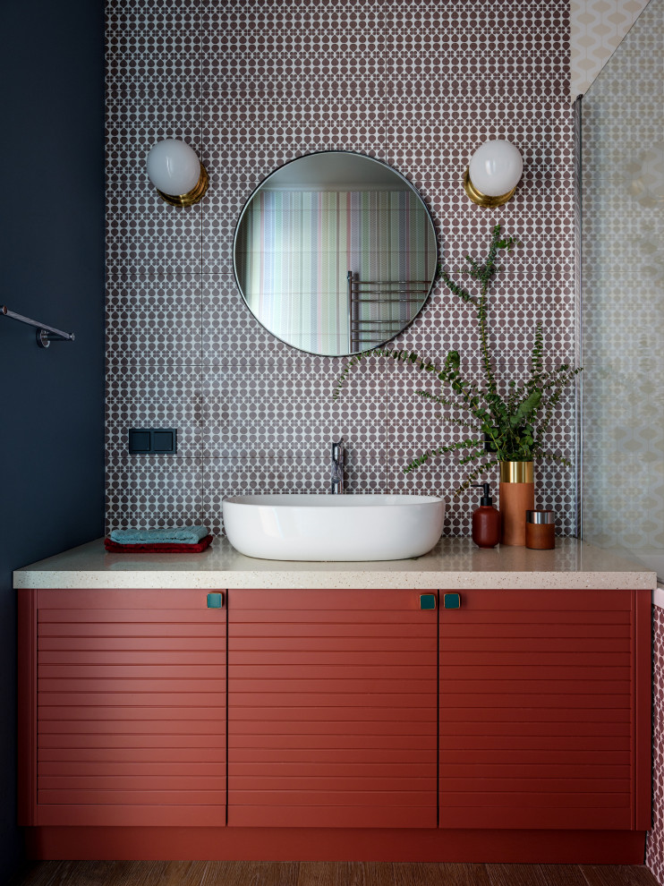Inspiration för ett litet funkis beige beige en-suite badrum, med flerfärgad kakel, keramikplattor, klinkergolv i keramik, bänkskiva i akrylsten, brunt golv, släta luckor, röda skåp, svarta väggar och ett fristående handfat