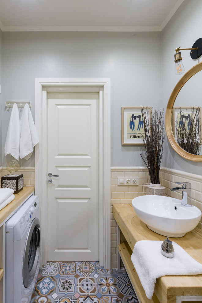Foto på ett litet eklektiskt badrum med dusch, med öppna hyllor, skåp i ljust trä, en hörndusch, en vägghängd toalettstol, beige kakel, tunnelbanekakel, grå väggar, cementgolv, ett fristående handfat, träbänkskiva, flerfärgat golv och dusch med skjutdörr