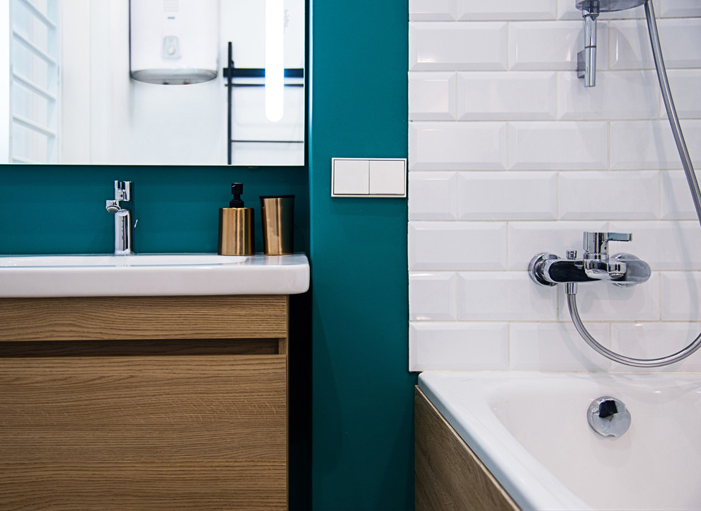 Пример оригинального дизайна: главная ванная комната в современном стиле с плоскими фасадами, фасадами цвета дерева среднего тона, душем над ванной, белой плиткой, плиткой кабанчик, синими стенами и накладной раковиной
