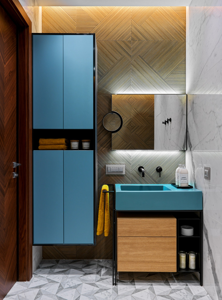 Modern inredning av ett badrum, med turkosa skåp, ett integrerad handfat och grått golv