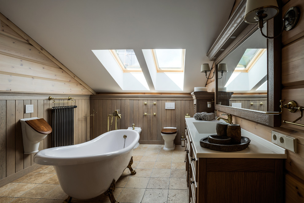На фото: главная ванная комната в стиле кантри с монолитной раковиной, фасадами цвета дерева среднего тона, ванной на ножках, писсуаром, бежевой плиткой, коричневыми стенами и фасадами с утопленной филенкой с