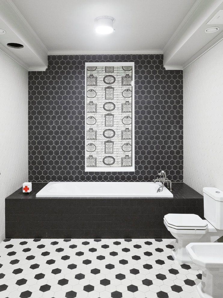 Cette image montre une salle de bain traditionnelle de taille moyenne avec un carrelage noir et blanc, une baignoire posée, WC séparés et du carrelage bicolore.