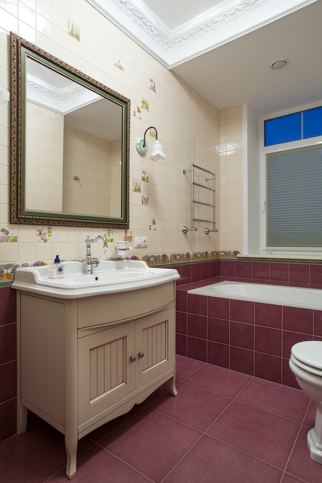 Diseño de cuarto de baño infantil clásico con puertas de armario beige, baldosas y/o azulejos beige, baldosas y/o azulejos rojos, bañera empotrada, sanitario de dos piezas, lavabo integrado y armarios con paneles empotrados