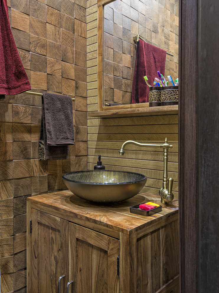 Aménagement d'une petite salle de bain principale éclectique en bois brun avec WC à poser, un carrelage marron, des carreaux de porcelaine, un sol en carrelage de porcelaine, une vasque, un plan de toilette en bois et un sol marron.
