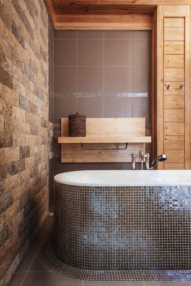 Rustikales Badezimmer En Suite mit freistehender Badewanne, Mosaikfliesen, brauner Wandfarbe, grauen Fliesen und Steinwänden in Moskau