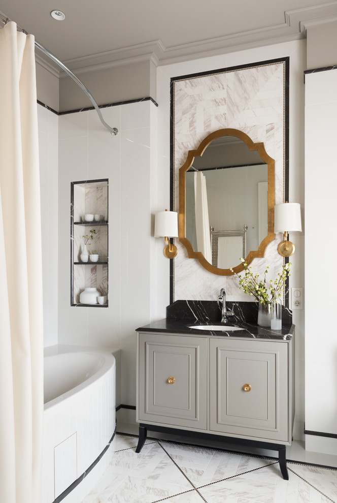 Пример оригинального дизайна: главная ванная комната в стиле неоклассика (современная классика) с белой плиткой, серыми стенами, врезной раковиной, белым полом, серыми фасадами, шторкой для ванной, фасадами с утопленной филенкой, отдельно стоящей ванной и душем над ванной
