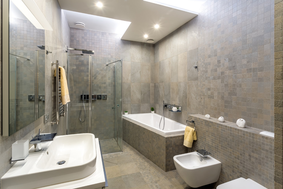 モスクワにあるコンテンポラリースタイルのおしゃれな浴室 (ドロップイン型浴槽、コーナー設置型シャワー、グレーのタイル、ベッセル式洗面器、グレーの床、白い洗面カウンター) の写真