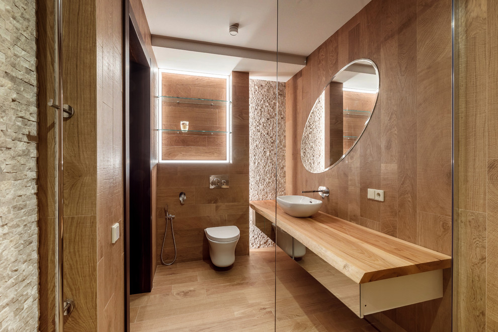 На фото: ванная комната в стиле кантри с плоскими фасадами, инсталляцией, коричневой плиткой, душевой кабиной, настольной раковиной, коричневым полом и коричневой столешницей с