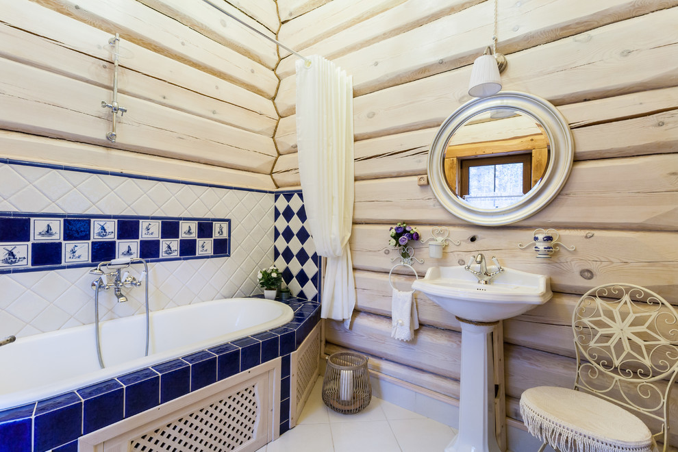 Foto di una stanza da bagno stile rurale con piastrelle blu, piastrelle bianche, lavabo a colonna, vasca da incasso, vasca/doccia, pareti bianche e doccia con tenda
