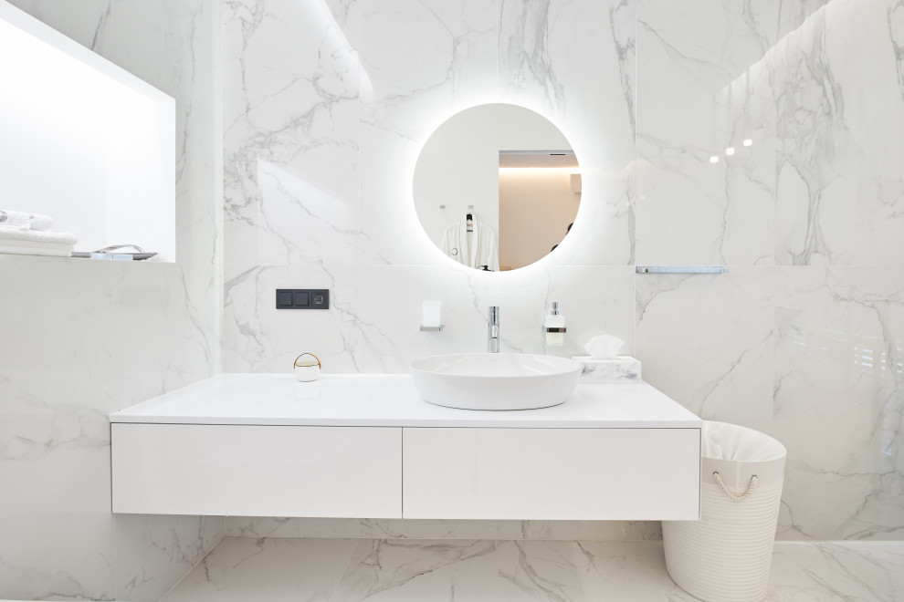 Esempio di una stanza da bagno con doccia minimal di medie dimensioni con ante lisce, ante bianche, piastrelle grigie, piastrelle in gres porcellanato, lavabo a bacinella, top in superficie solida, pavimento grigio e top bianco