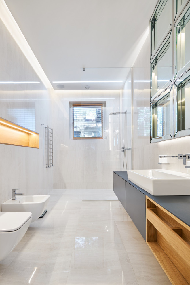 На фото: большая главная ванная комната в современном стиле с плоскими фасадами, серыми фасадами, открытым душем, инсталляцией, белой плиткой, настольной раковиной, белым полом и серой столешницей