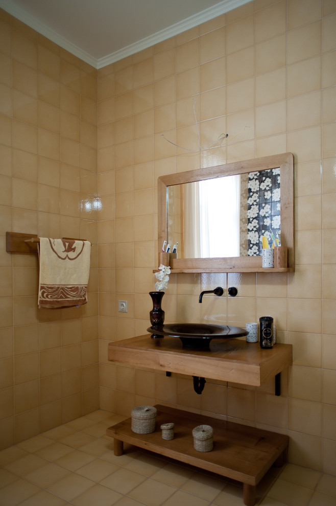 На фото: ванная комната в современном стиле с бежевой плиткой, настольной раковиной и бежевым полом с
