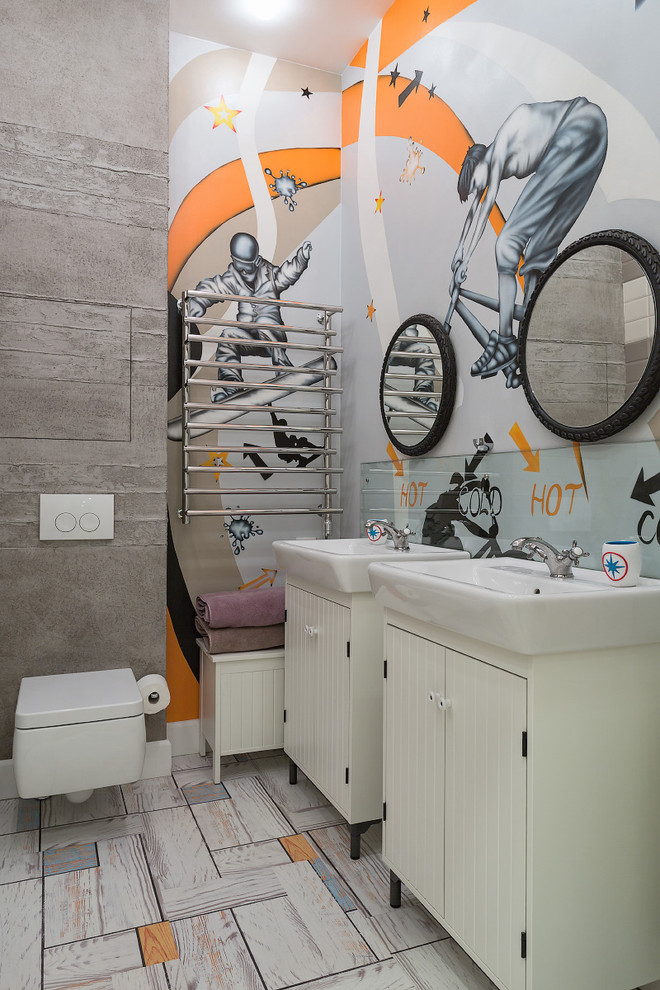 Cette photo montre une salle de bain tendance pour enfant avec un placard à porte plane, des portes de placard blanches, WC suspendus, un mur gris et un plan vasque.