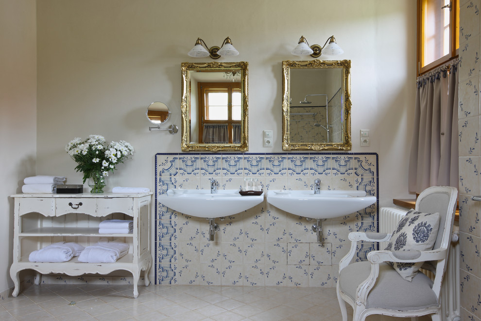Exempel på ett stort klassiskt en-suite badrum, med släta luckor, vita skåp, en toalettstol med separat cisternkåpa, vit kakel, keramikplattor, vita väggar, klinkergolv i keramik, ett väggmonterat handfat och träbänkskiva