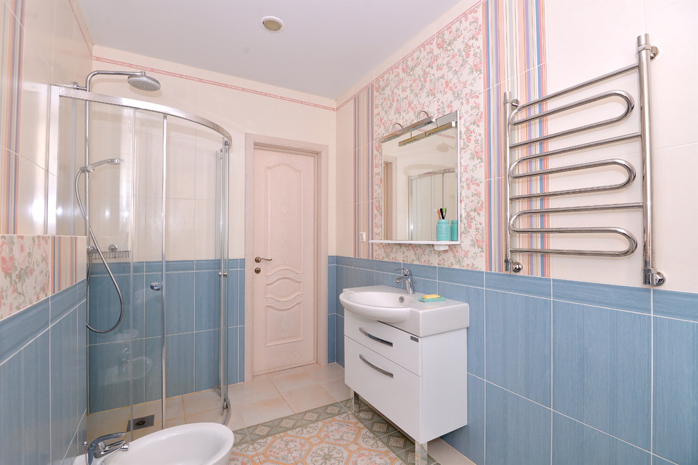 Cette photo montre une salle de bain principale tendance de taille moyenne avec une douche d'angle, un carrelage beige, un carrelage bleu, des carreaux de céramique, un mur beige, un sol en carrelage de céramique et un plan vasque.
