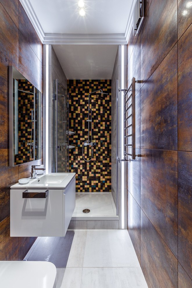 Bild på ett litet funkis badrum med dusch, med släta luckor, vita skåp, en dusch i en alkov, brun kakel, ett integrerad handfat, grått golv och dusch med skjutdörr