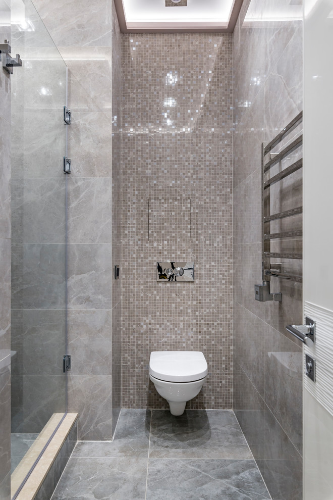 Ispirazione per una stanza da bagno con doccia contemporanea con doccia alcova, WC sospeso, piastrelle beige, piastrelle a mosaico, pavimento grigio e porta doccia a battente
