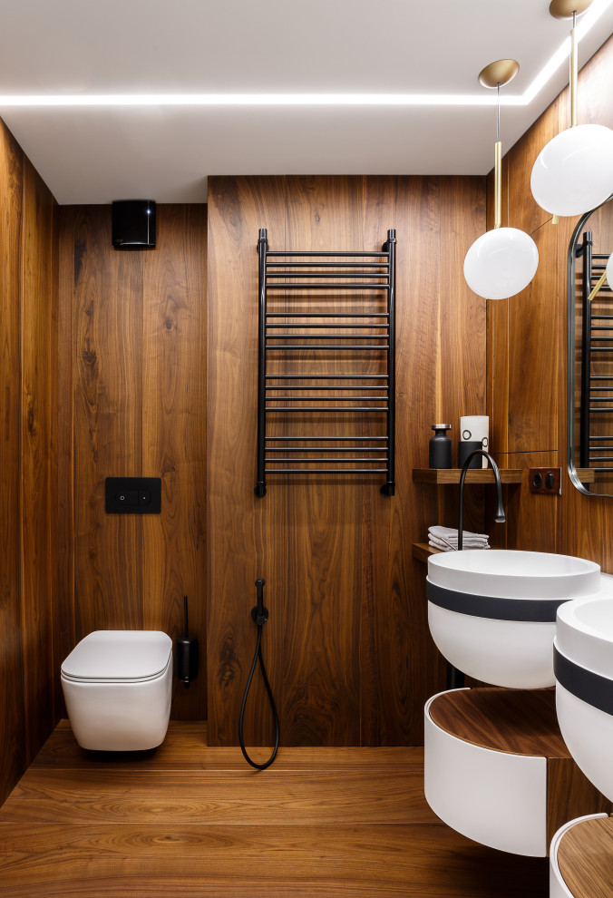 Bild på ett funkis badrum, med bruna väggar, mellanmörkt trägolv, ett väggmonterat handfat och brunt golv