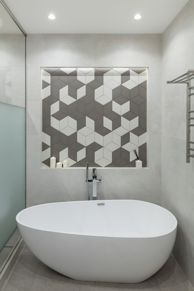 Ispirazione per una stanza da bagno padronale design con vasca freestanding, piastrelle grigie e pavimento grigio