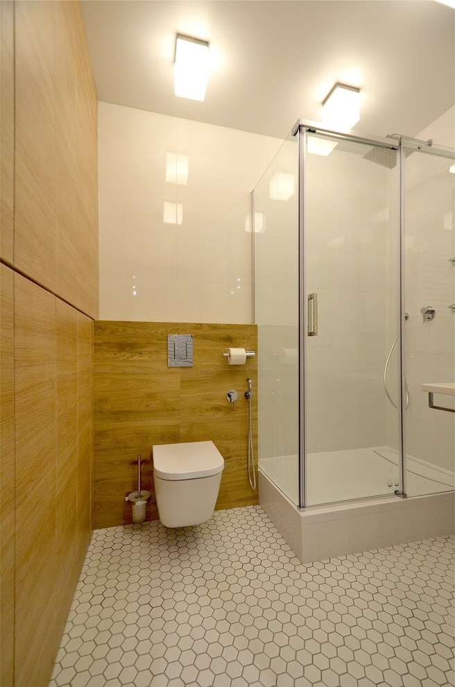Пример оригинального дизайна: маленькая главная ванная комната в современном стиле с плоскими фасадами, фасадами цвета дерева среднего тона, угловым душем, инсталляцией, белой плиткой, керамогранитной плиткой, белыми стенами, полом из мозаичной плитки, подвесной раковиной, белым полом, душем с раздвижными дверями и гигиеническим душем для на участке и в саду