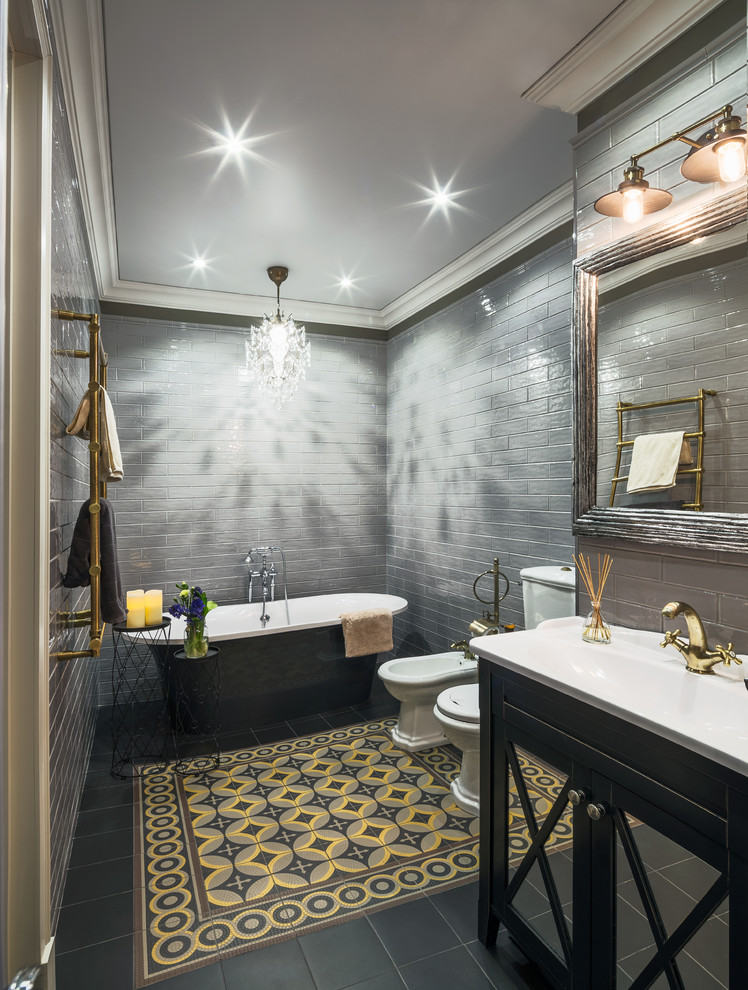 Стильный дизайн: главная ванная комната в классическом стиле с стеклянными фасадами, черными фасадами, отдельно стоящей ванной, биде, серой плиткой и монолитной раковиной - последний тренд