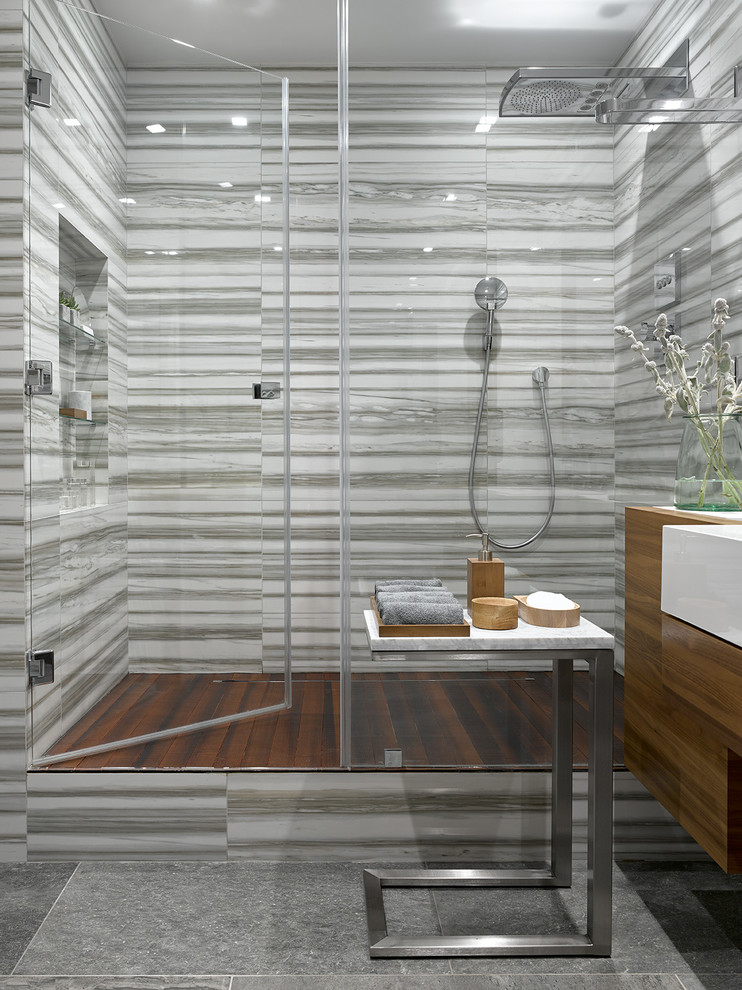 Cette image montre une douche en alcôve design avec un carrelage gris et une cabine de douche à porte battante.