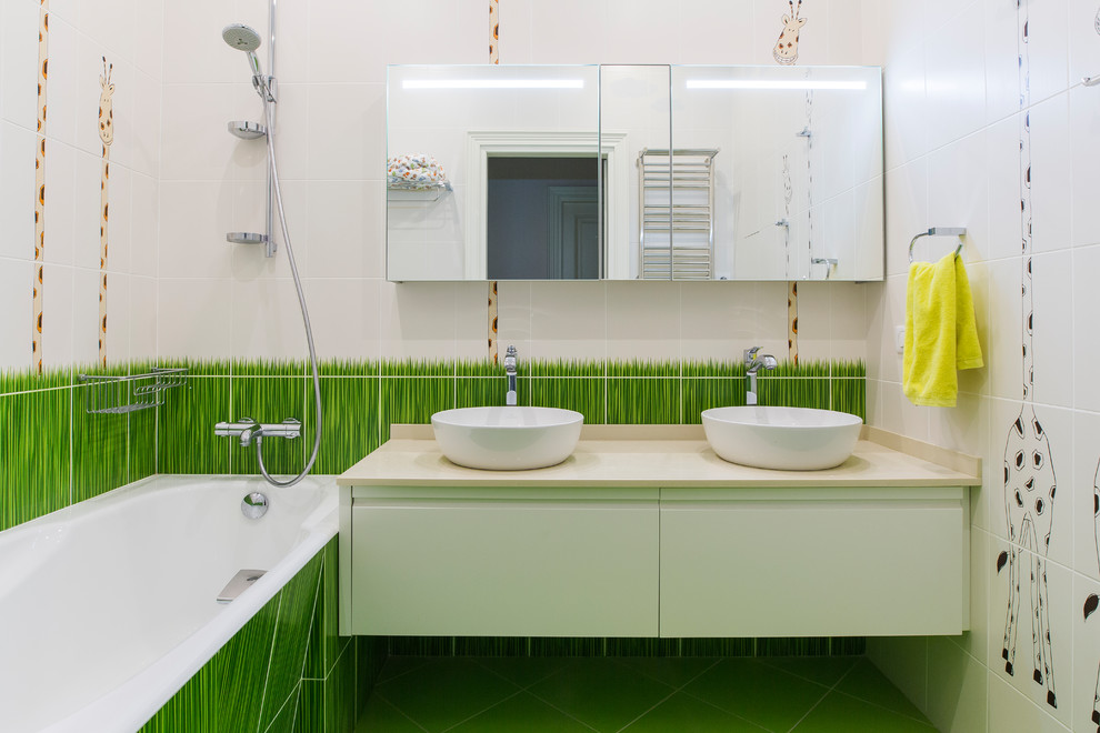 На фото: детская ванная комната в современном стиле с плоскими фасадами, белыми фасадами, душем над ванной, белой плиткой, разноцветной плиткой, настольной раковиной, зеленым полом, разноцветными стенами и открытым душем