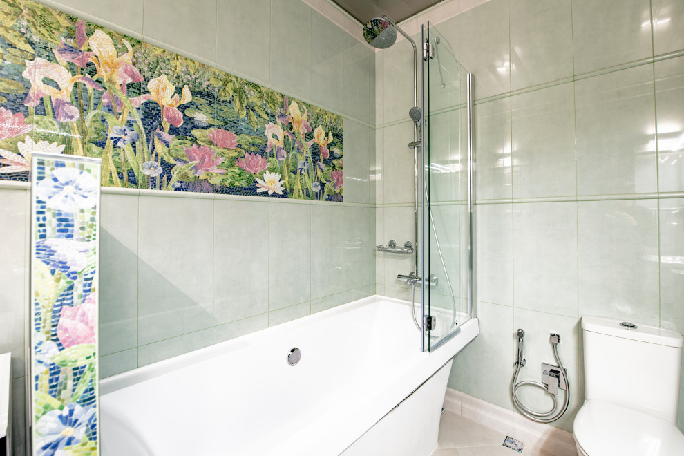 На фото: ванная комната в современном стиле с отдельно стоящей ванной, душем над ванной, раздельным унитазом, зеленой плиткой и бежевым полом