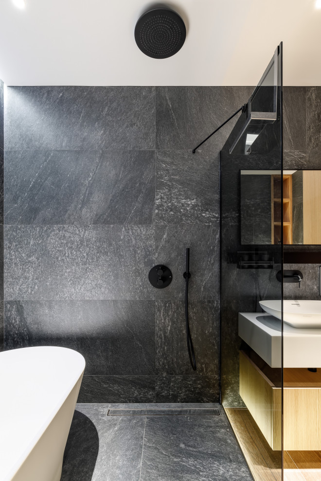 Modernes Badezimmer mit freistehender Badewanne, Nasszelle, schwarzen Fliesen und schwarzem Boden in Sankt Petersburg