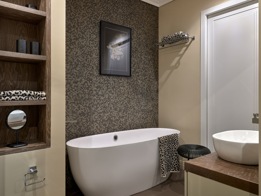Photo of a contemporary ensuite bathroom in Moscow with brown tiles, mosaic tiles, beige walls, porcelain flooring, a vessel sink, wooden worktops, brown floors, brown worktops, a floating vanity unit and a freestanding bath.
