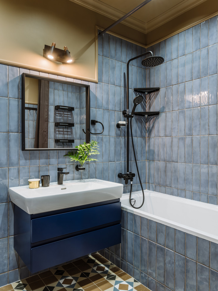 Modern inredning av ett en-suite badrum, med släta luckor, blå skåp, en dusch/badkar-kombination, blå kakel, beige väggar och dusch med duschdraperi