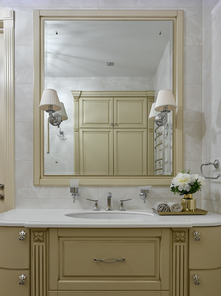Стильный дизайн: ванная комната в стиле неоклассика (современная классика) с фасадами с выступающей филенкой, бежевыми фасадами, белой плиткой, врезной раковиной и бежевым полом - последний тренд