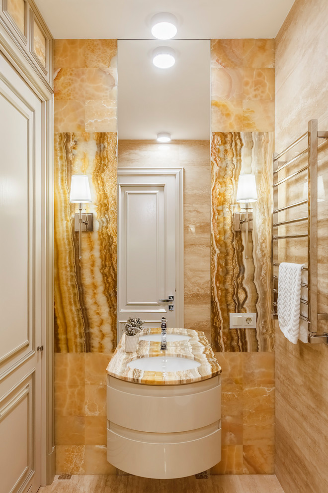 На фото: ванная комната в стиле неоклассика (современная классика) с белыми фасадами, желтой плиткой, плиткой из листового камня, врезной раковиной, столешницей из оникса, бежевым полом, бежевой столешницей и полом из травертина с