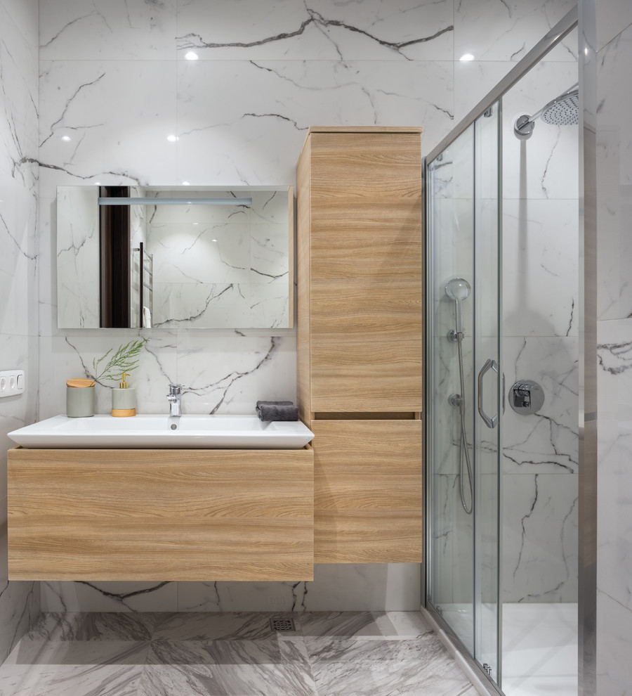 Aménagement d'une douche en alcôve contemporaine en bois clair avec un placard à porte plane, un carrelage blanc, un plan vasque, un sol gris et une cabine de douche à porte coulissante.