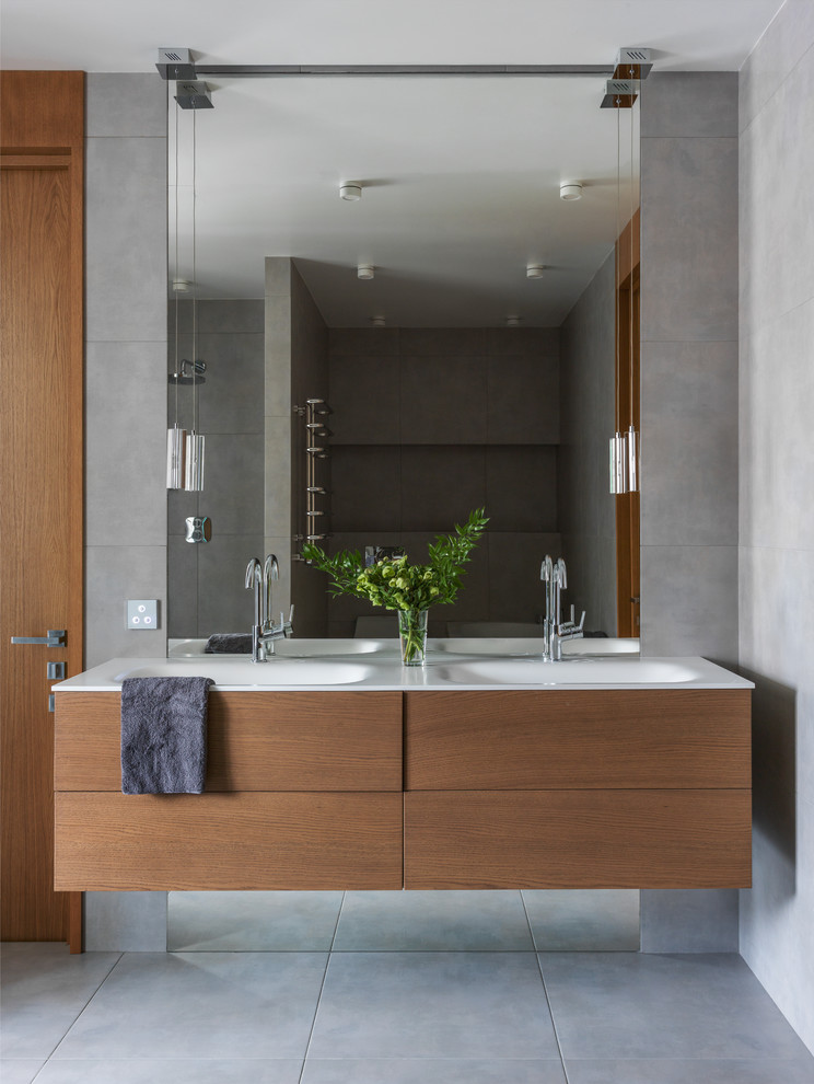 Ispirazione per una stanza da bagno padronale minimal con ante lisce, ante in legno scuro, piastrelle grigie, pavimento grigio, pareti grigie e lavabo integrato