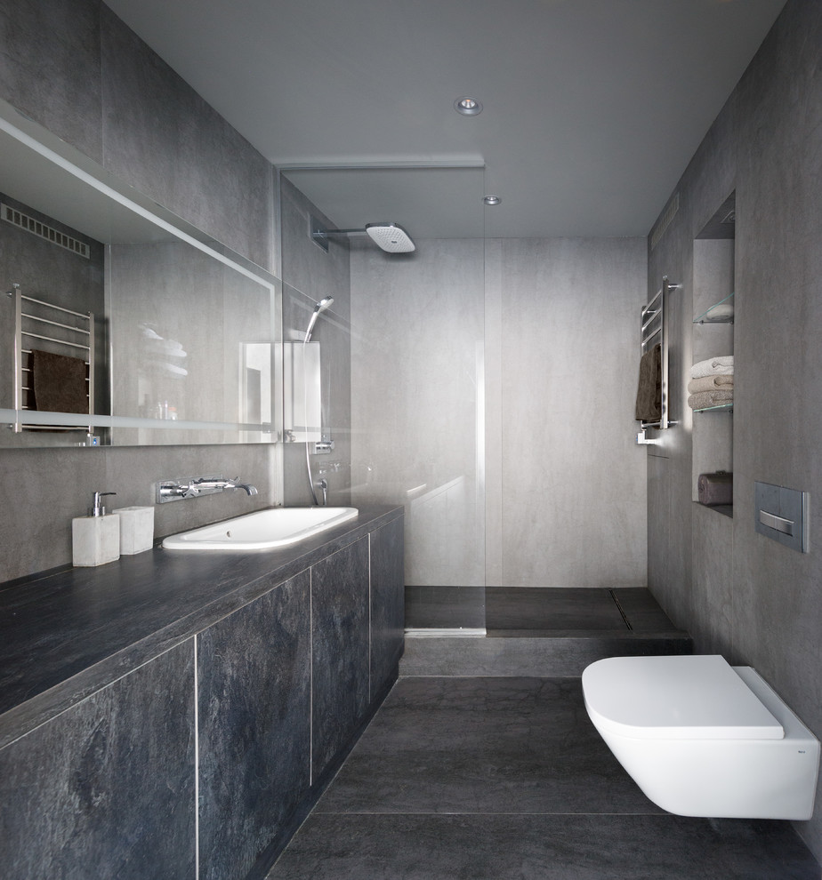 Idee per una stanza da bagno con doccia contemporanea con ante lisce, ante grigie, doccia alcova, WC sospeso, pareti grigie, lavabo da incasso, pavimento grigio, doccia aperta e top grigio