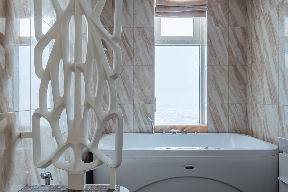 На фото: большая главная ванная комната в скандинавском стиле с плоскими фасадами, белыми фасадами, гидромассажной ванной, инсталляцией, бежевой плиткой, керамогранитной плиткой, бежевыми стенами, полом из керамогранита, столешницей из искусственного камня и коричневым полом