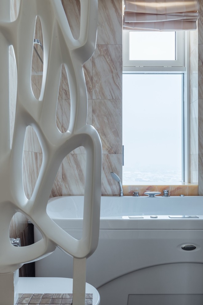 На фото: большая главная ванная комната в скандинавском стиле с плоскими фасадами, белыми фасадами, гидромассажной ванной, инсталляцией, бежевой плиткой, керамогранитной плиткой, бежевыми стенами, полом из керамогранита, столешницей из искусственного камня и коричневым полом с