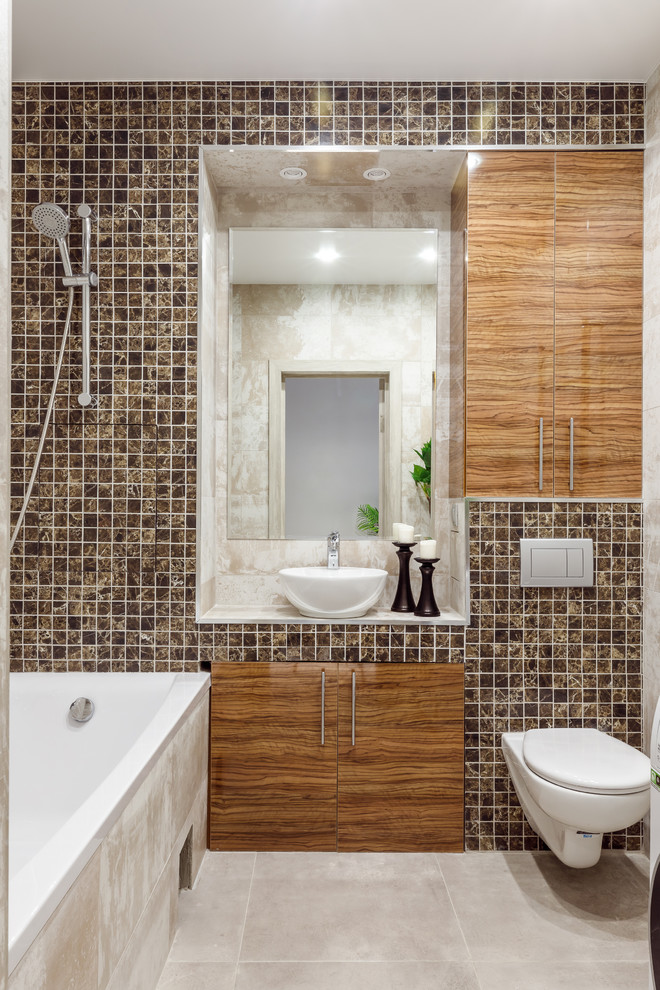 Idée de décoration pour une salle de bain principale design en bois brun avec un placard à porte plane, WC suspendus, mosaïque, une vasque, un plan de toilette blanc, un sol beige, une baignoire encastrée, un carrelage beige et un plan de toilette en carrelage.